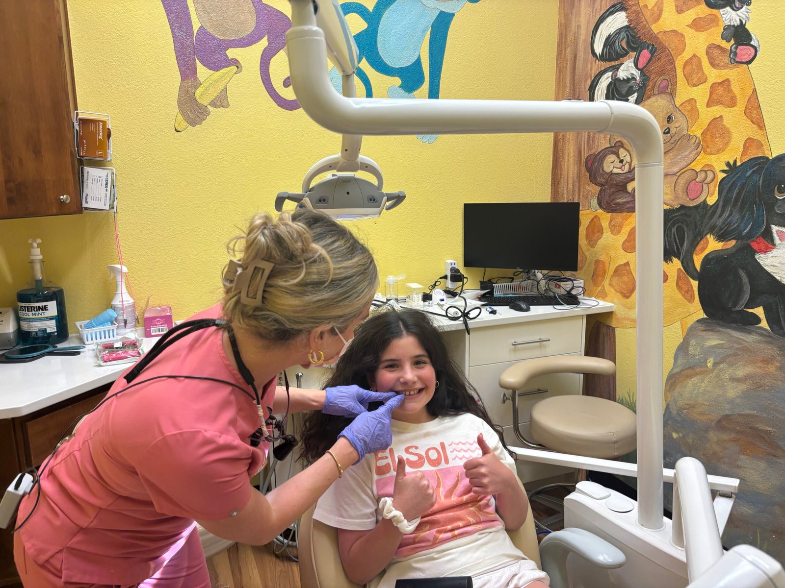 Star Dental team member gently examining a smiling child in a colorful treatment room