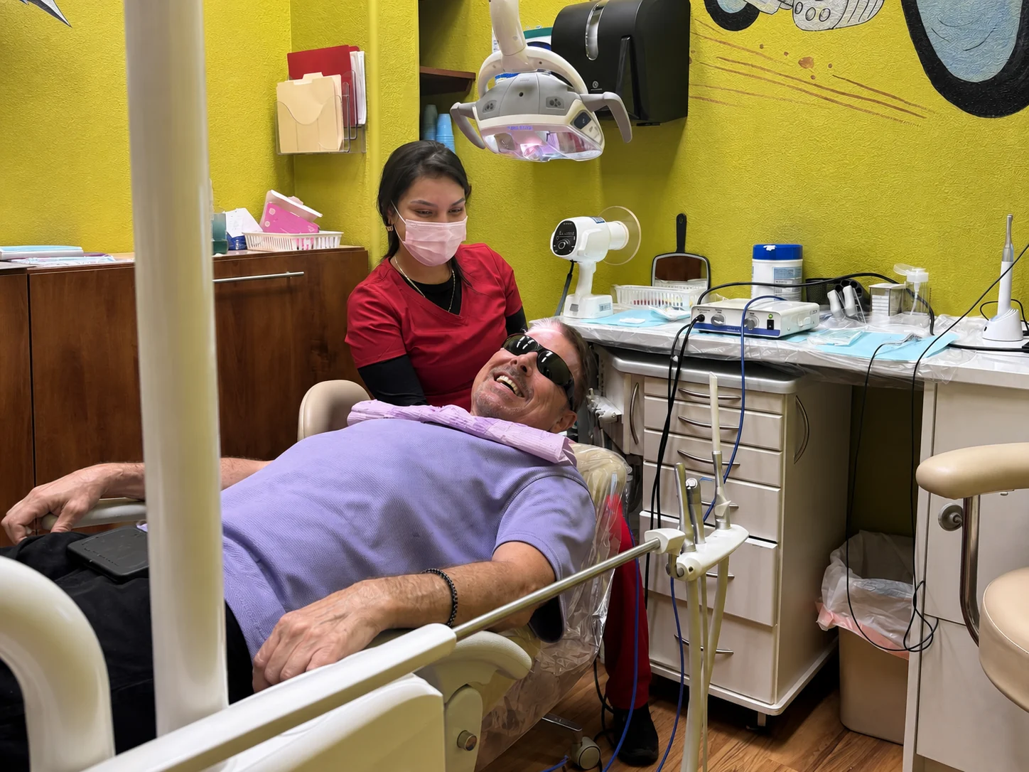 Star Dental team member with a smiling patient in a treatment room at the Denver office