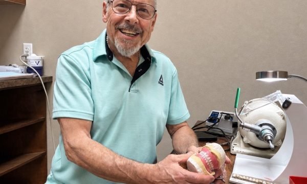 Star Dental on-site denture technician holding a denture model